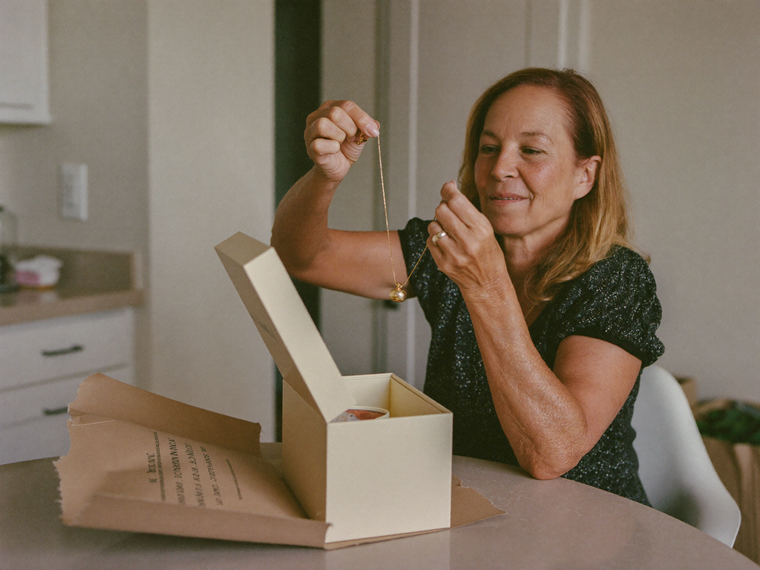 A customer opening her Prescott Jewelry delivery at home